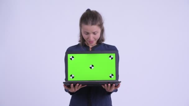 Heureuse jeune belle femme d'affaires montrant ordinateur portable et regardant surpris — Video