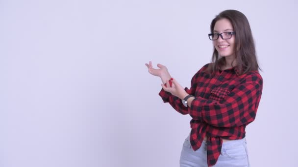 Lycklig ung vacker hipster kvinna som visar något på bak sidan — Stockvideo
