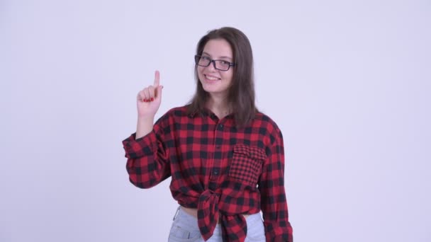 Feliz joven hermosa mujer hipster señalando hacia arriba — Vídeos de Stock