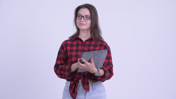 Счастливая молодая красивая хипстерша думает, используя цифровой планшет — стоковое видео