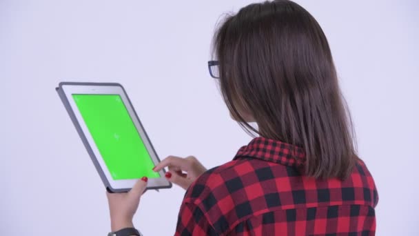 Vue arrière de la jeune femme de hipster utilisant la tablette numérique