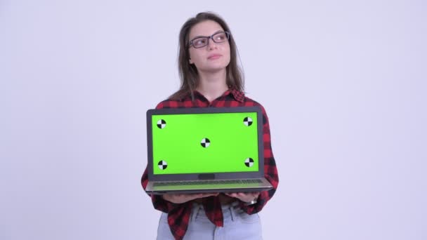 Jovem feliz bela mulher hipster pensando ao mostrar laptop — Vídeo de Stock