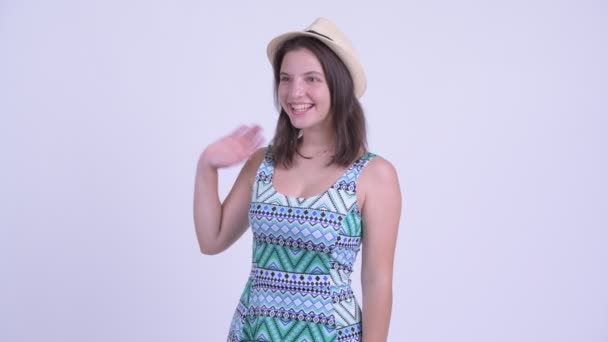 Happy young beautiful tourist woman waving hand — Stock Video