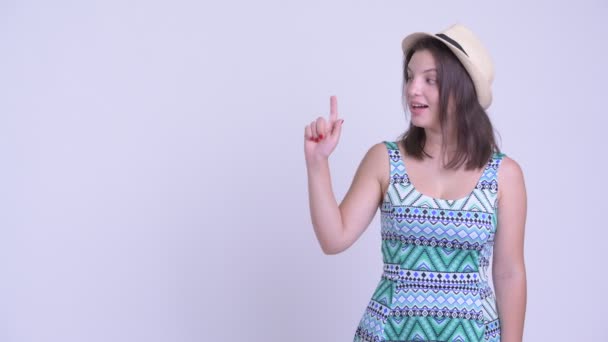 Gelukkig jonge mooie toeristische vrouw denken en wijzen op — Stockvideo