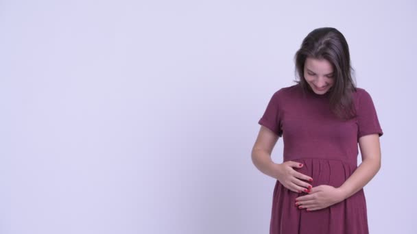 Jovem feliz bela mulher grávida mostrando algo para as costas — Vídeo de Stock