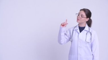 Mutlu genç güzel kadın doktor düşünme ve işaret yukarı