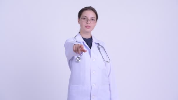 Feliz joven hermosa mujer médico apuntando a la cámara — Vídeo de stock