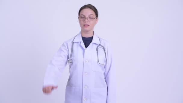 Serious young woman doctor giving thumbs down — Stock Video