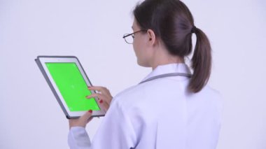 Dijital tablet kullanarak mutlu genç kadın doktorun arka görünümü