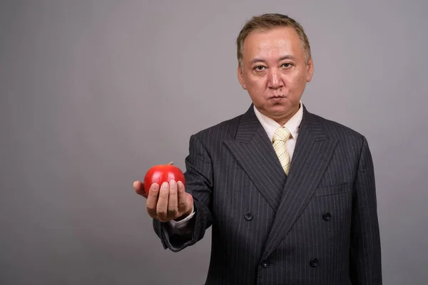 Портрет зрілих азіатських бізнесмена проти сірий фон — стокове фото