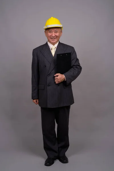Maturo asiatico costruzione uomo d'affari contro grigio sfondo — Foto Stock