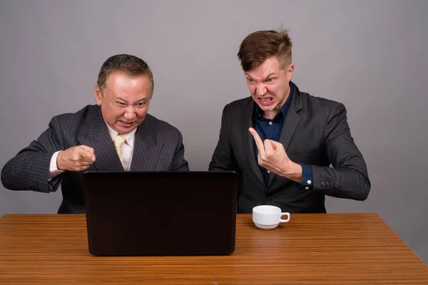 Mature Asian businessman and young Scandinavian businessman agai — Stock Photo, Image