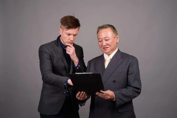 Mogen asiatisk affärsman och ung skandinavisk affärsman agai — Stockfoto