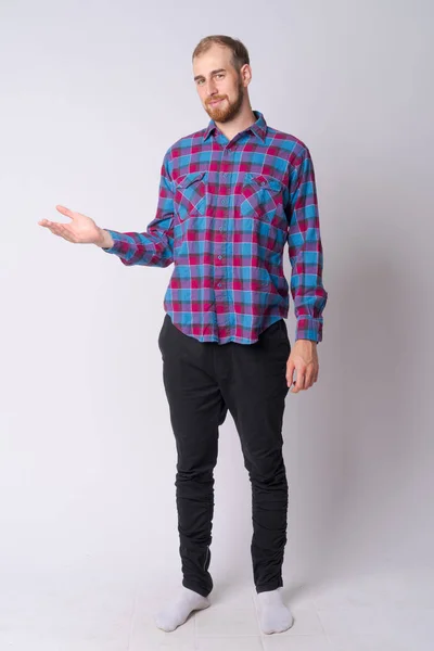 Full body shot of young bearded hipster man showing something — Stock Photo, Image