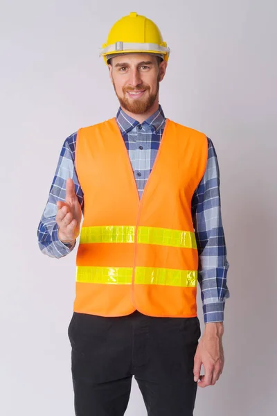 Happy young bearded man construction worker giving handshake — Stock Photo, Image