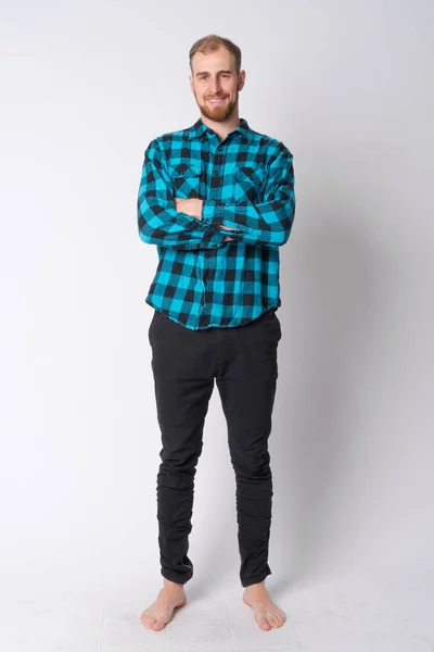 Bote de cuerpo completo de joven y feliz barbudo hipster hombre sonriendo con los brazos cruzados — Foto de Stock