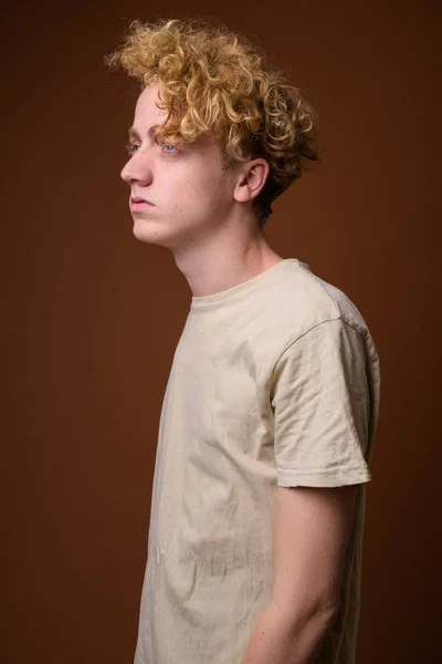 Flaco joven con el pelo rizado sobre fondo marrón — Foto de Stock