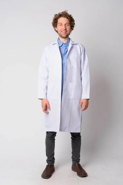 Full body shot of happy man doctor with curly hair smiling — Stock Photo, Image