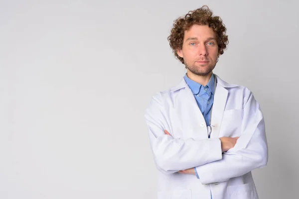 Porträt eines gut aussehenden Mannes Arzt mit lockigem Haar verschränkten Armen — Stockfoto