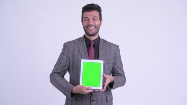 Счастливый бородатый персидский бизнесмен думает, показывая цифровой планшет — стоковое видео