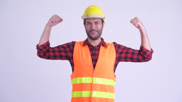 Heureux homme barbu perse travailleur de la construction fléchissant les deux bras — Video