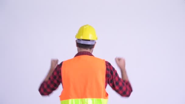 Zadní pohled na šťastného vousatého muže na stavební práce se zdviženými pěstmi — Stock video