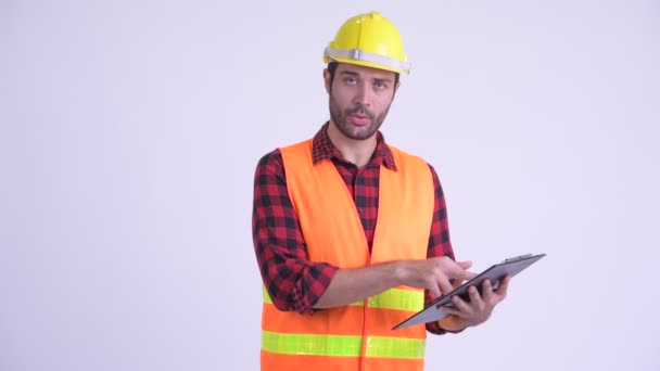 Heureux homme barbu perse travailleur de la construction parler tout en lisant sur presse-papiers — Video