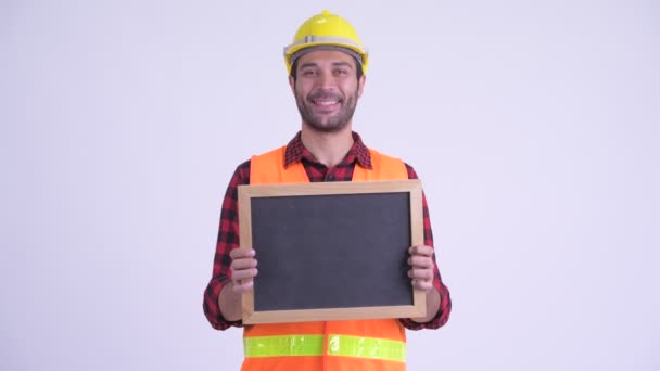 Happy bearded Persian man construction worker holding blackboard — Stock Video