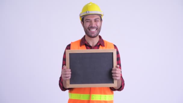 Happy skäggiga persisk man byggnadsarbetare innehar Blackboard och ser förvånad — Stockvideo