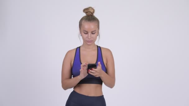 Lycklig ung vacker blond kvinna tänkande när du använder telefonen — Stockvideo
