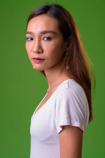 Joven delgado asiático mujer contra verde fondo —  Fotos de Stock