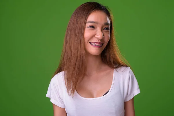 Giovane sottile donna asiatica contro sfondo verde — Foto Stock