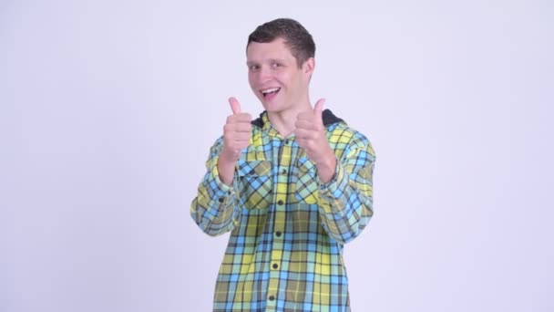 Jovem homem bonito feliz dando polegares para cima e olhando animado — Vídeo de Stock