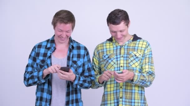 Birlikte telefon kullanan iki mutlu genç adam — Stok video