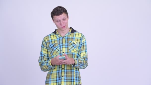 Šťastný mladý pohledný muž myšlení při používání telefonu — Stock video