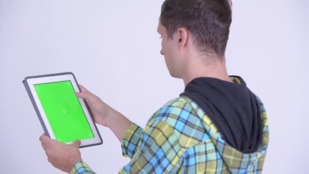 Achteraanzicht van de jonge man met behulp van digitale Tablet — Stockvideo