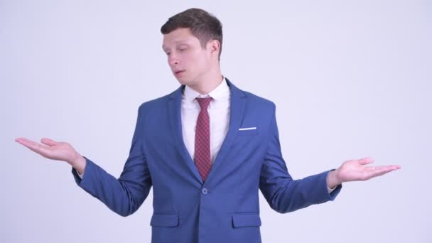 Glücklicher junger gutaussehender Geschäftsmann, der etwas vergleicht — Stockvideo