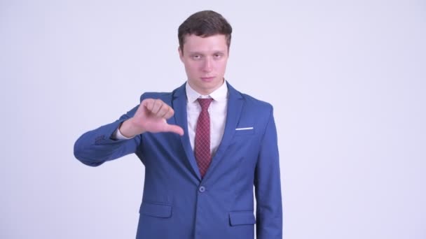 Злой молодой бизнесмен подает большие пальцы — стоковое видео
