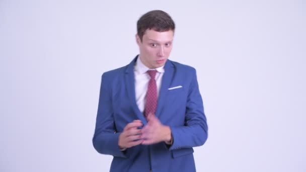 Glücklicher junger gutaussehender Geschäftsmann sieht überrascht aus — Stockvideo