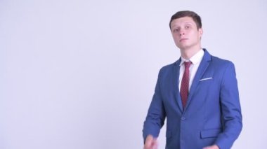 Mutlu genç yakışıklı işadamının kollar geçti ile gülümseyen profil görünümü