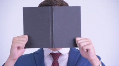 Kitabın arkasına saklanan genç işadamının yüzü