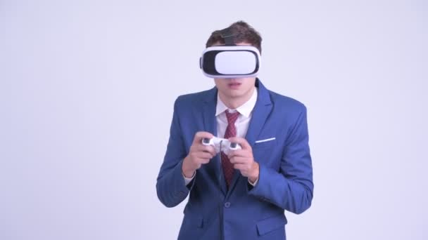 Joven hombre de negocios guapo jugando juegos con auriculares de realidad virtual — Vídeo de stock