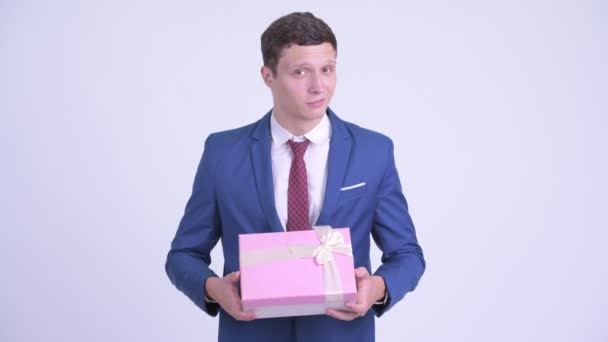 Feliz joven hombre de negocios guapo dando caja de regalo — Vídeo de stock