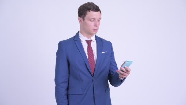 Feliz joven hombre de negocios guapo usando el teléfono y recibiendo buenas noticias — Vídeos de Stock