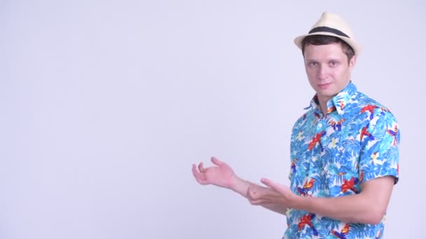 Heureux jeune homme beau touriste montrant quelque chose à l'arrière 