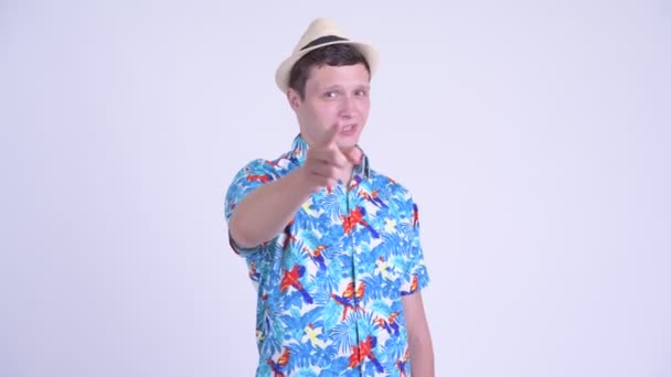 Heureux jeune homme beau touriste pointant vers la caméra 
