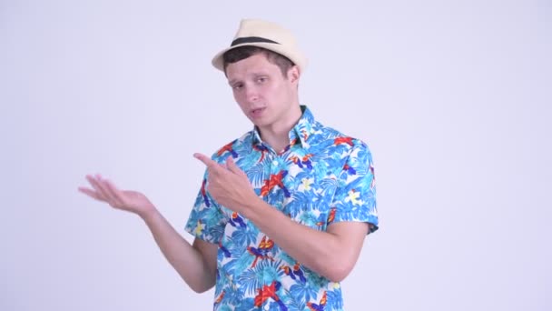 Mutlu genç yakışıklı turist adam bir şey sunan — Stok video