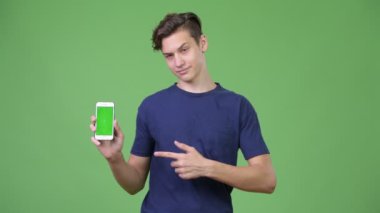 Telefonunu gösteren genç yakışıklı çocuk.