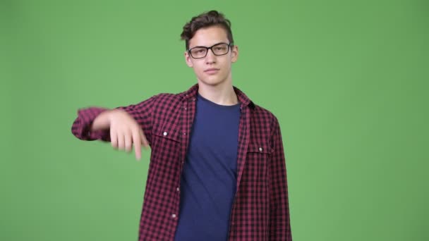 Joven guapo adolescente nerd chico señalando el dedo hacia arriba — Vídeo de stock