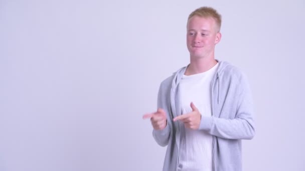 Щасливий молодий блондинка вказує пальці і показує щось — стокове відео